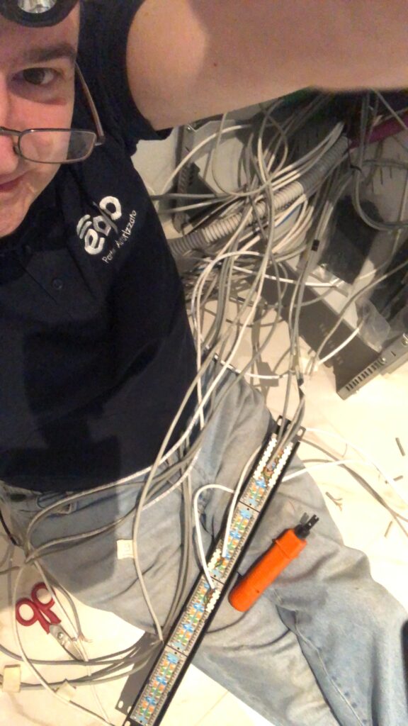 Attestazione dei cavi di rete su un patch panel con l'attrezzo a impatto durante un cablaggio