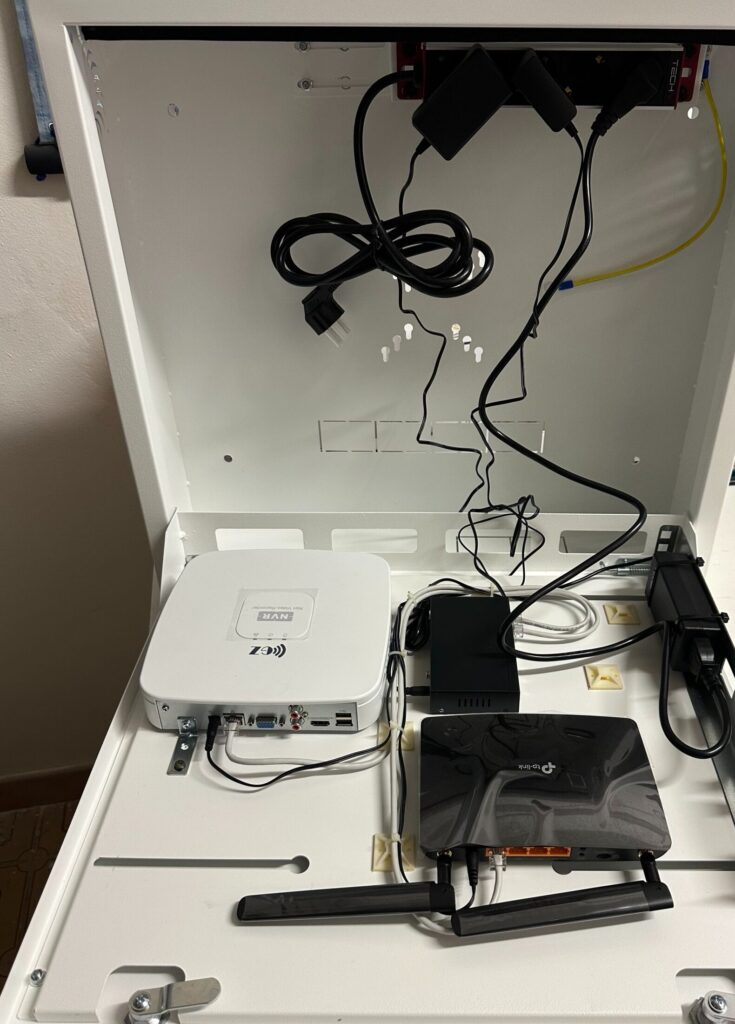 Cassetta metallica per videosorveglianza in preparazione, con registratore NVR, router 4G e alimentazione degli apparati